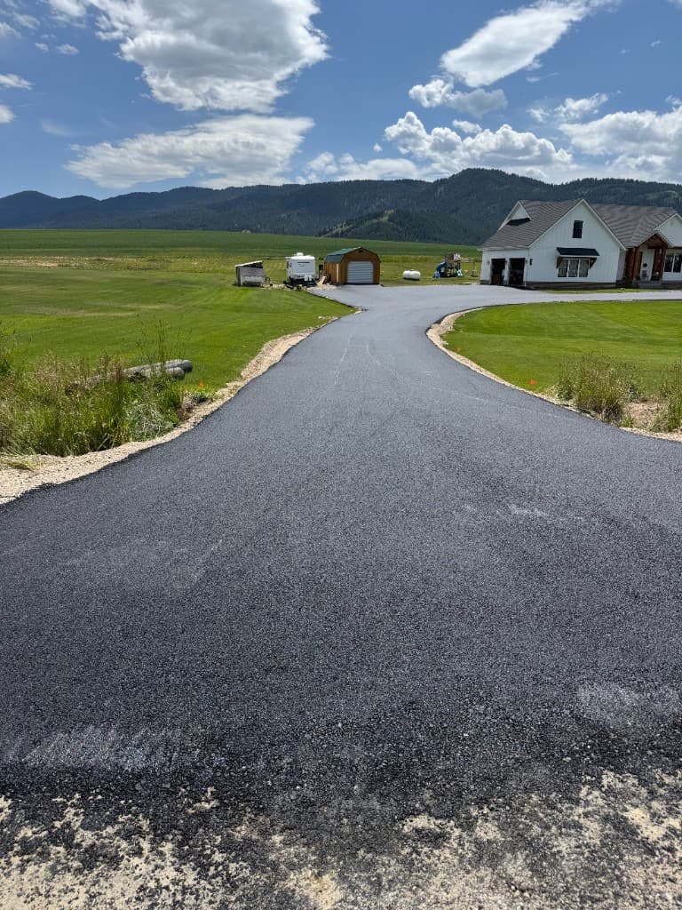 Paved driveway through green landscape